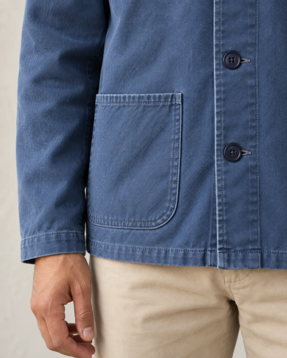 Detalle del bolsillo de parche y los botones de la chaqueta de trabajo azul